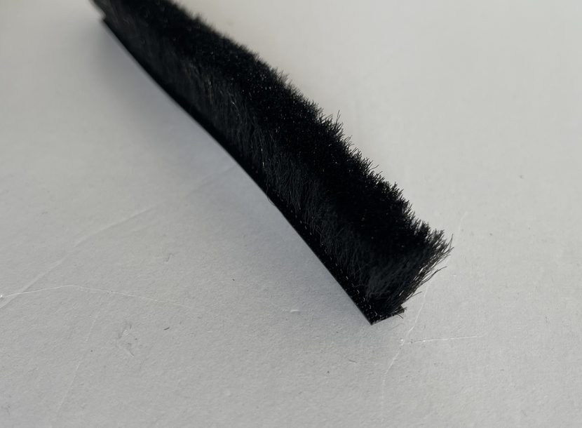 Heat-set pile standing upright off the backing rather than leaning.